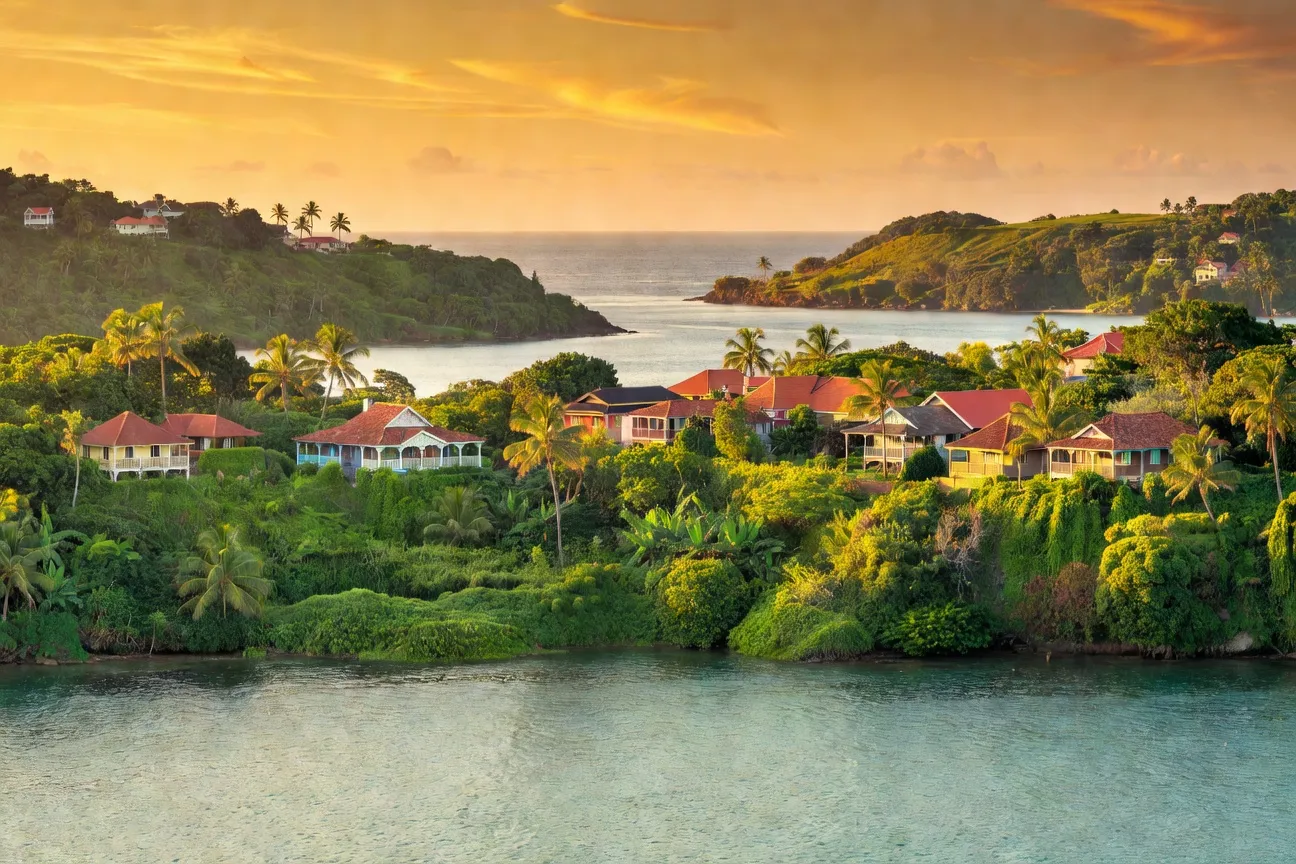 Vue de Fort-de-France depuis la mer avec végétation tropicale et couleurs chaudes