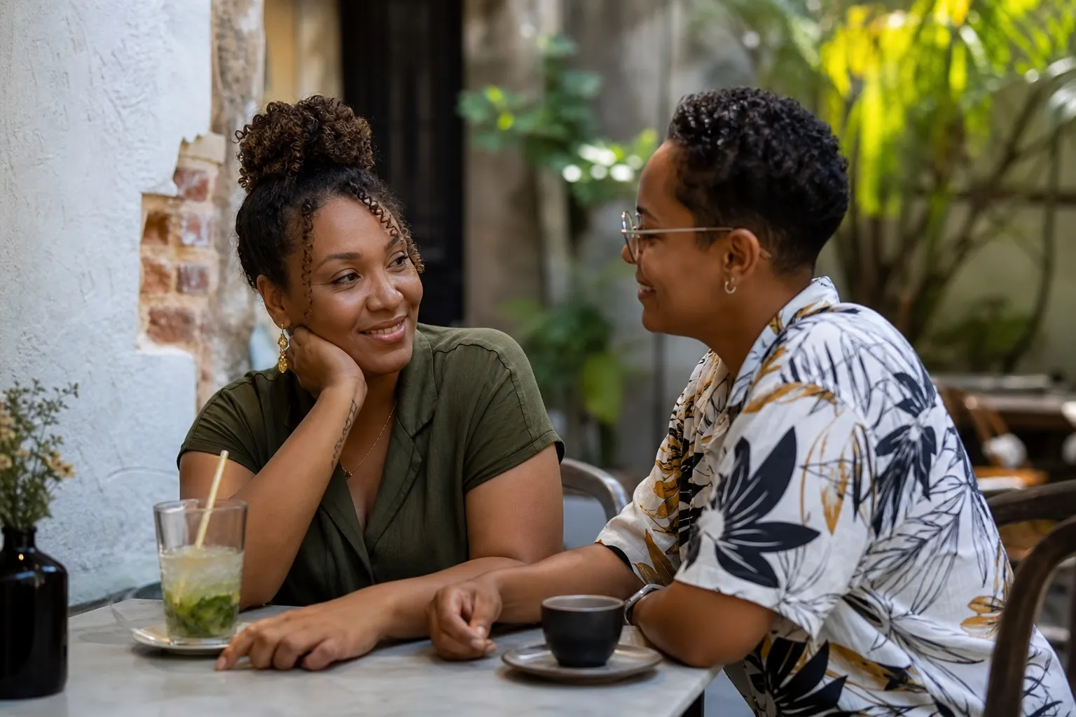 Deux femmes LGBTQ+ échangent dans un café tropical discret en Martinique